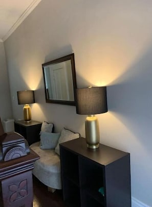 Relax in a cozy space with a comfortable armchair, dresser, and lamps.