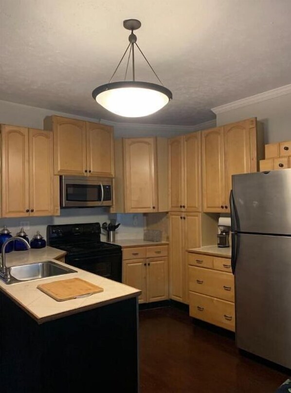 Kitchen features a central island, stainless steel appliances, and a functional layout.
