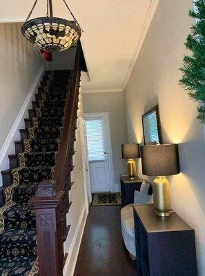 Stunning staircase with intricate patterns and a beautiful hanging light fixture.