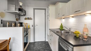 A modern kitchen with a built-in dishwasher, a stainless steel sink, and a variety of kitchen appliances. - Nice apartment in Hemmet with sauna (Hemmet)