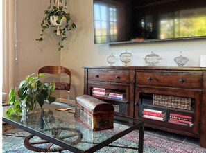 Relax in this inviting living room with a coffee table, comfortable chair, and flat-screen TV.