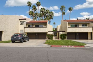 A row of two-story buildings with a car parked in front. - Beautiful Biltmore condo. (Palm Springs)