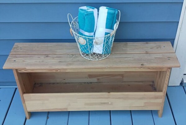 Un banco de madera con una cesta de mimbre encima.