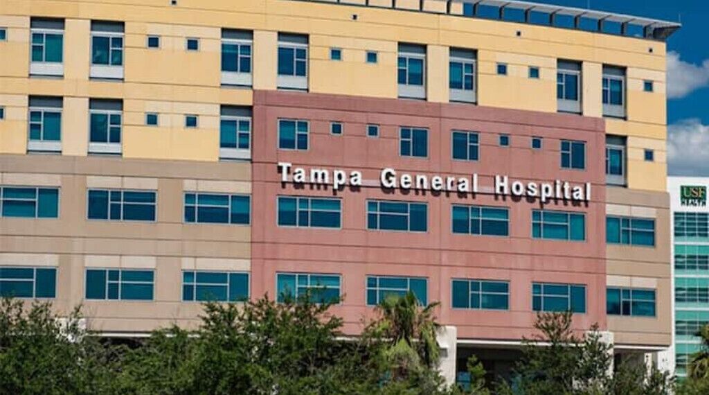 A multi-story building with the sign "Tampa General Hospital" on the facade.