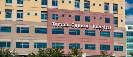 A multi-story building with the sign "Tampa General Hospital" on the facade.
