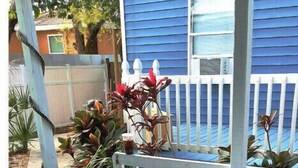 An outdoor hot tub with a wooden deck and a white fence. - Tropical Tiny house with Outdoor jacuzzi & Gazebo (Tampa)