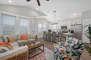 Relax in this stylish living space with a comfortable sofa, coffee table, and vibrant armchair.