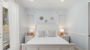 A bedroom with a large bed, two bedside tables, and a ceiling light. - Newly Remodeled 2BR/2B Condo (South Padre Island)