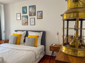 A bedroom with a bed, a nightstand, a lamp, and wall art. - LE CARNOT Apartment for 2 By Sunset (Antibes)