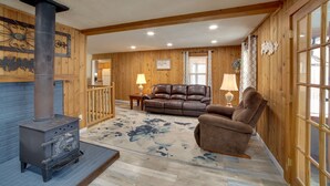 A cozy living room with a fireplace, leather sofa, and a floral rug.