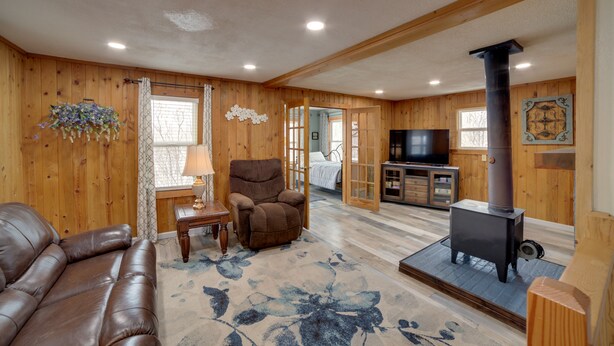 A cozy living room with a leather couch, a brown recliner, a fireplace, and a television.