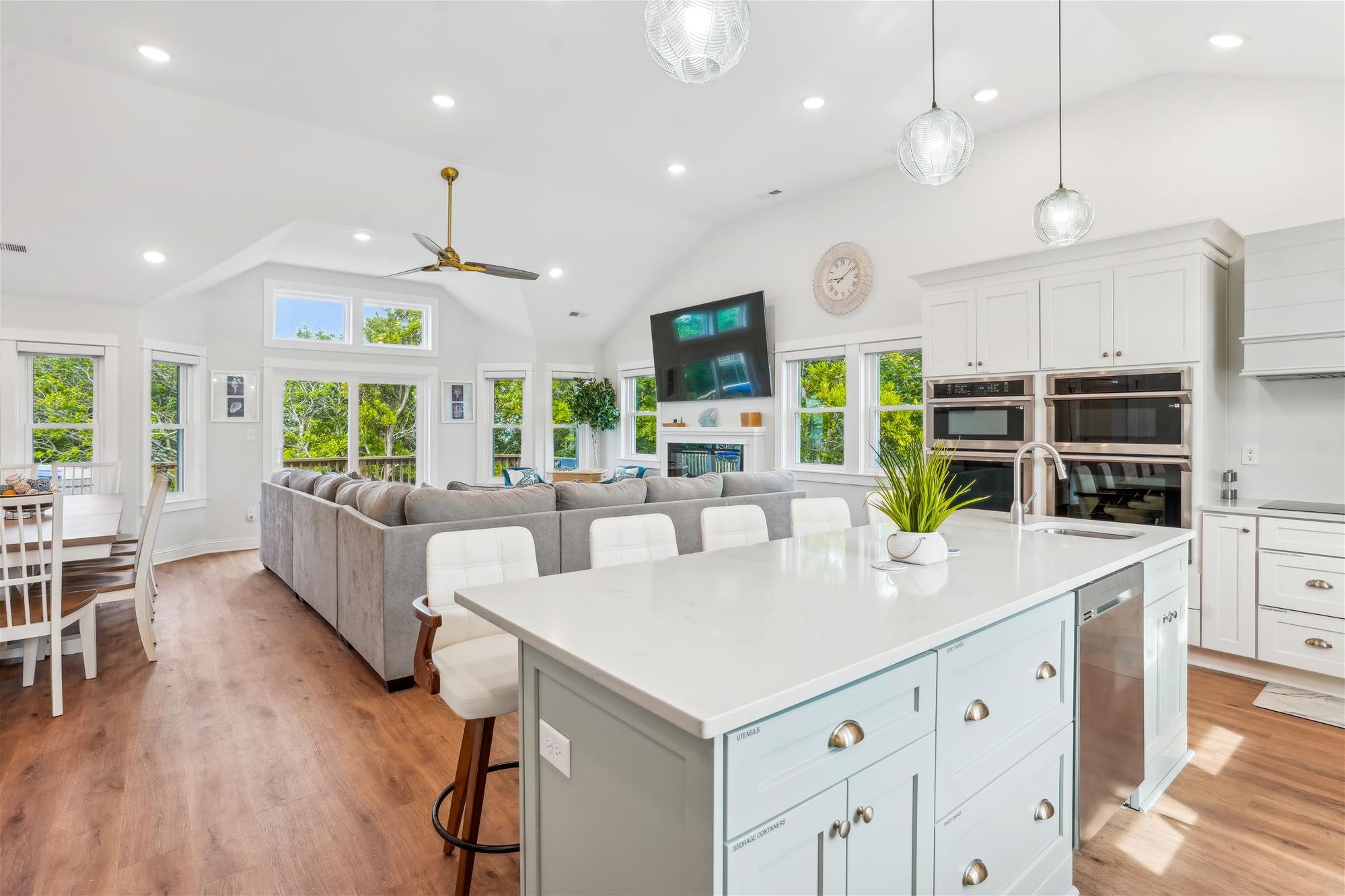 A spacious kitchen with white cabinetry, a central island, and a dining area with a sofa.