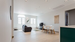 A spacious living area with a sofa, dining table, chairs, and a television. - Casa Love 1D (Panama City)
