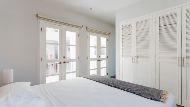 A hotel room with a large bed, white walls, and a wardrobe with sliding doors. - Casa Love 1D (Panama City)