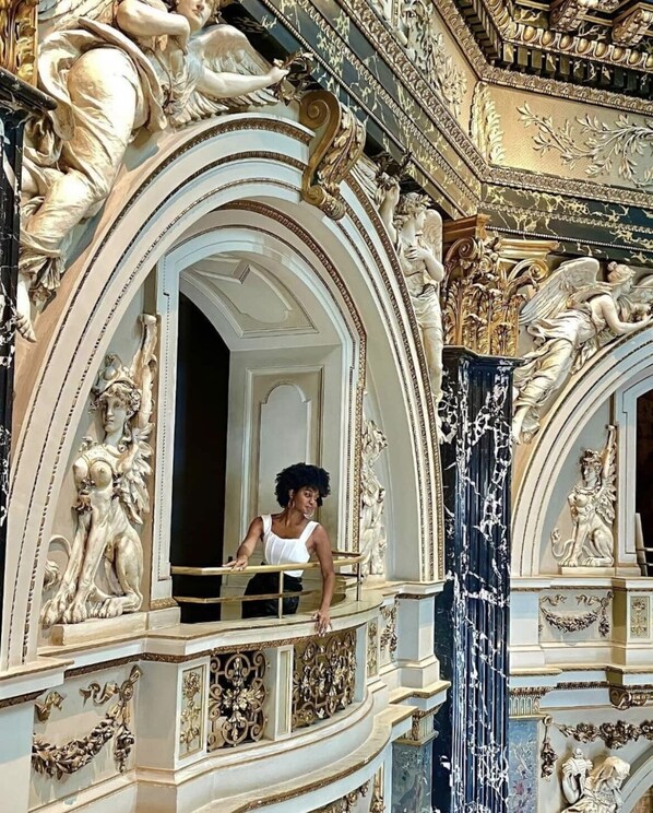 A grand architectural interior with ornate sculptures and detailed moldings.