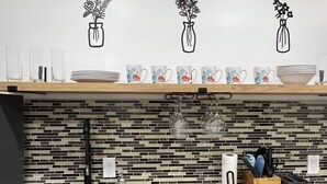 A kitchen with a tiled backsplash, a wooden countertop, a toaster, a kettle, and a coffee maker. - Trendy in Tremont, Cleveland U (Cleveland)