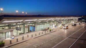 An airport terminal with a modern glass facade, a covered waiting area, and a clear sky at dusk. - Trendy in Tremont, Cleveland U (Cleveland)