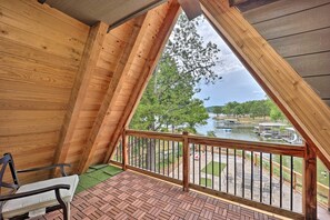 A wooden balcony with a view of a lake and dock area. - Stunning lakefront A-frame home w/ dock! 15% off 4+ nt stay! (Eucha)