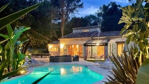 A pool area with lounge chairs and a stone building with a tiled roof. - Charming Estate on 1Ha: 3 Houses, Heated 28 °C Pool, SPA, Ideal for Families (Roquefort les pins)