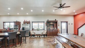 Una cocina amplia con una isla grande, sillas de madera oscura y una mesa de comedor con bancos.