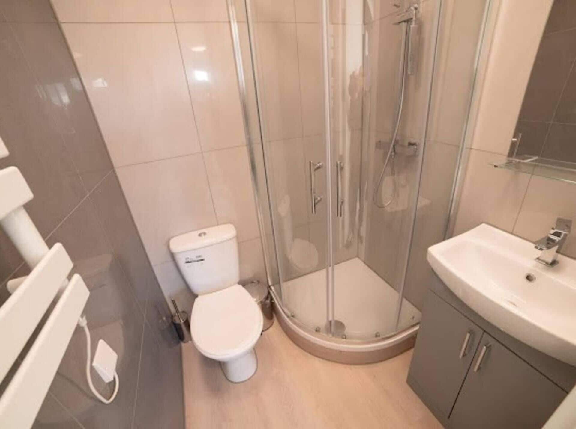 Een badkamer met toilet, een douchecabine en een wastafel.