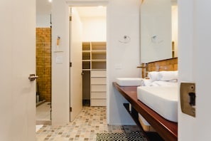 Un baño moderno con ducha, lavamanos y un mueble de almacenamiento.