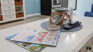A magazine on a table, a glass jar with a rope, and a remote control.