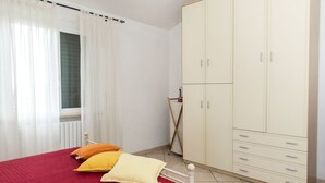 Une chambre à coucher avec un lit, une armoire et une fenêtre avec des rideaux.