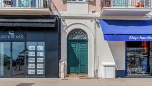 A storefront with a green door and a blue awning.
