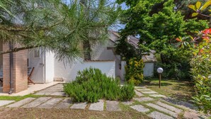 A residential property with a paved garden area, a brick wall, and a white building with a tiled roof. - Villa with garden on two levels (ground floor and first floor) with internal stairs.In 70 square meters of space, it comfortably accommodates 6 people with two bedrooms (one with a double bedroom, one with two single beds) and a double sofa bed in the li (Lido di Spina)