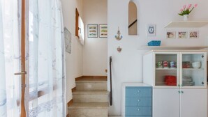 A staircase leading to a landing with a white cabinet and a blue drawer unit. - Villa with garden on two levels (ground floor and first floor) with internal stairs.In 70 square meters of space, it comfortably accommodates 6 people with two bedrooms (one with a double bedroom, one with two single beds) and a double sofa bed in the li (Lido di Spina)