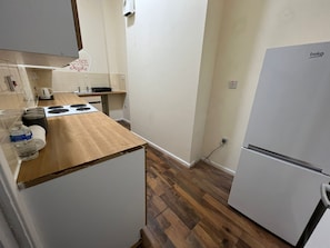 Kitchen area with a sink, stove, and refrigerator.