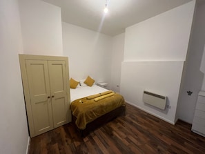 Cozy retreat with a single bed, bedside table, and wardrobe.