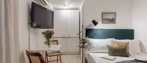 Tabla de planchar con plancha, internet y ropa de cama