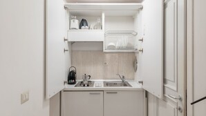 A compact kitchenette with a sink, a coffee maker, and a kettle. - GuestHost - Basic Studio - 350 m far from Fontana di Trevi (Roma)