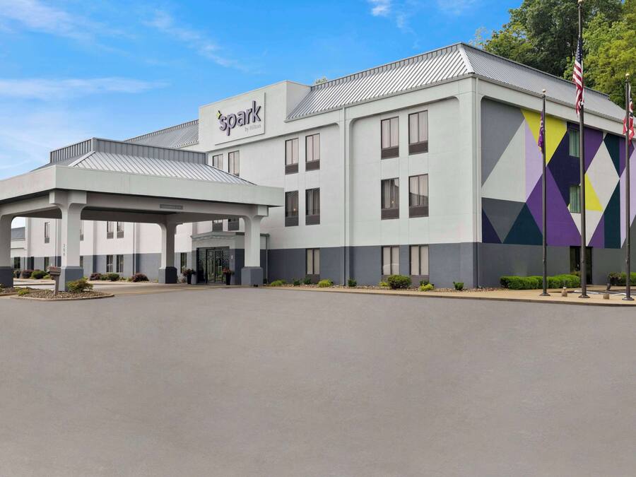 Ein modernes Hotel mit überdachter Eingangshalle, einem gut sichtbaren Logo und einer geometrischen Fassade.