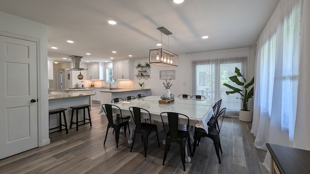 A spacious kitchen with a large island, modern appliances, and ample natural light from large windows. - Peaceful Gathering Place with 12 bedrooms and 7 bathrooms. Game Tables and Pool! (South Bend)