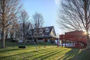 A residential area with a house, a swing set, and a red play structure.