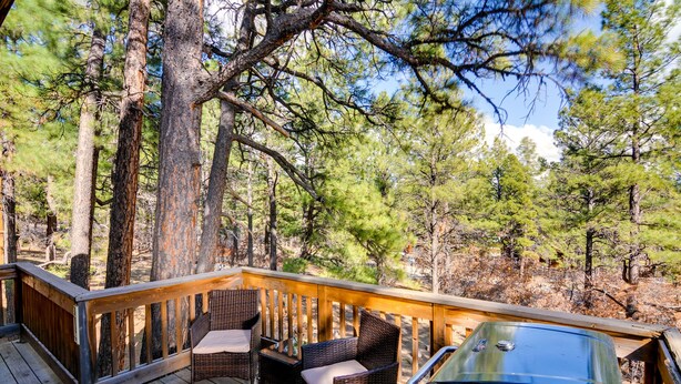 A wooden deck with wicker furniture and a grill. - Rustic Pagosa Springs Cabin w/ Hot Tub + Game Room (Pagosa Springs)