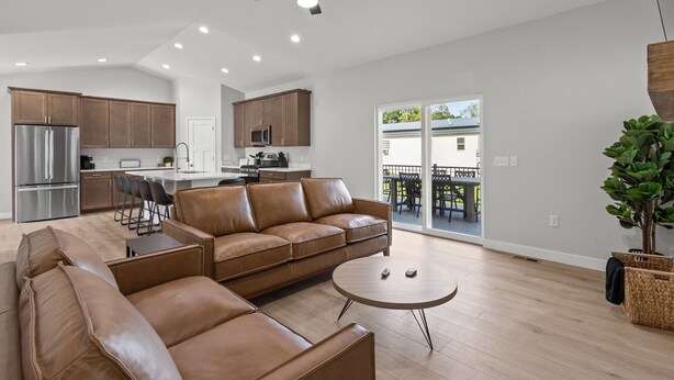 A spacious living room with a leather sofa, a round coffee table, and a ceiling fan. - The Dells Domain (Wisconsin Dells)
