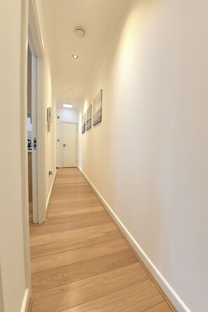 Enter a clean and uncluttered space with a door leading to a room.