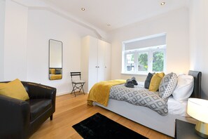 Relax in a stylish bedroom with a large bed, comfortable sofa, and modern decor.