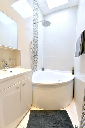 Enjoy a refreshing soak in the bathtub under the skylight.