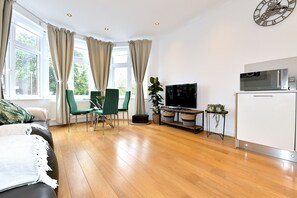 Relax in the living room with a sofa, chair, flat-screen TV, and microwave.