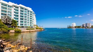 A coastal hotel with multiple floors, a clear view of the sea, and a rocky shoreline. - Family Studio · Ocean View · Water Backup (San Juan)