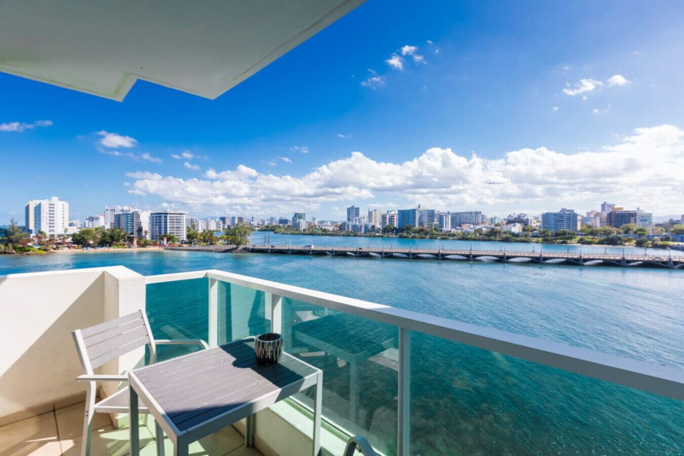 Un balcón con vistas a un horizonte urbano y una masa de agua.