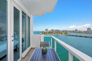 A balcony with a view of a city skyline and water. - Family Studio · Ocean View · Sleeps 4 (San Juan)