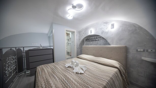 Ein Schlafzimmer mit einem Bett, einem Schminktisch, einem Spiegel und einem Kleiderschrank.