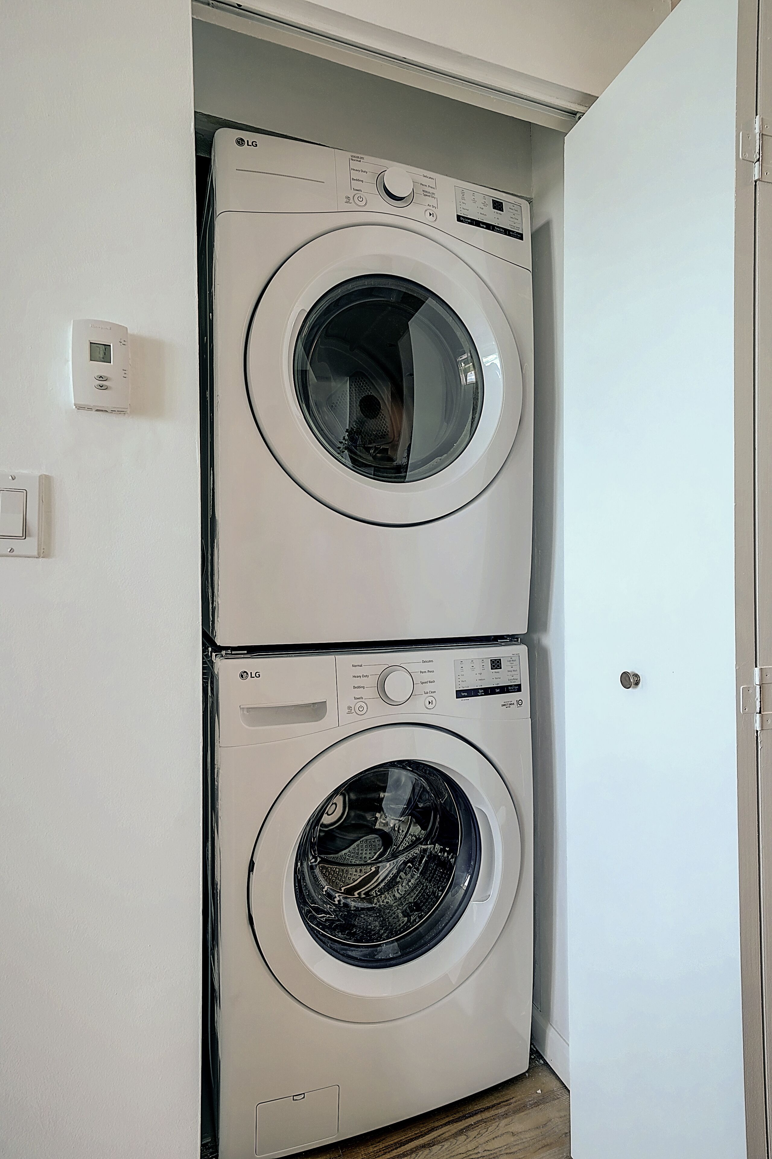 Une machine à laver et un sèche-linge superposés dans une buanderie.