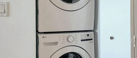 Une machine à laver et un sèche-linge superposés dans une buanderie.